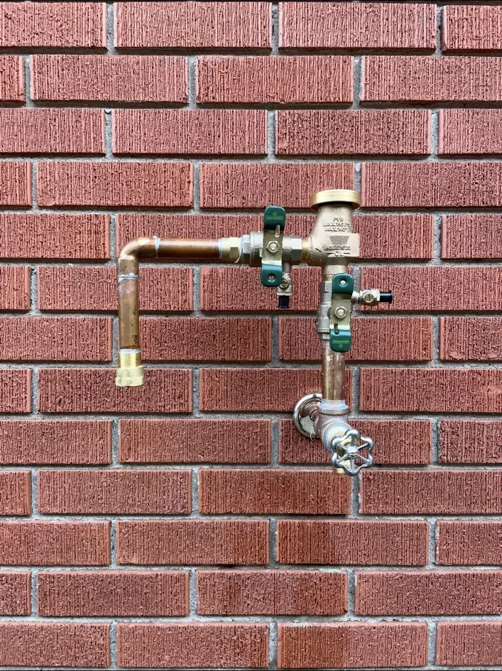 Backflow preventer installed on a brick wall