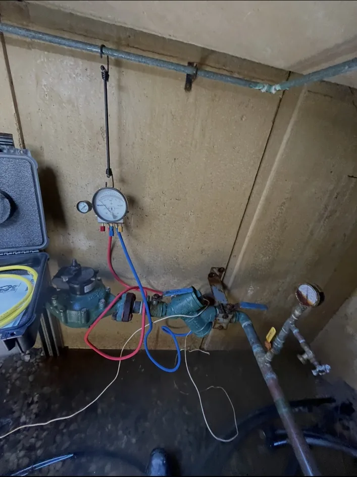 Backflow device being tested with gauge and hoses