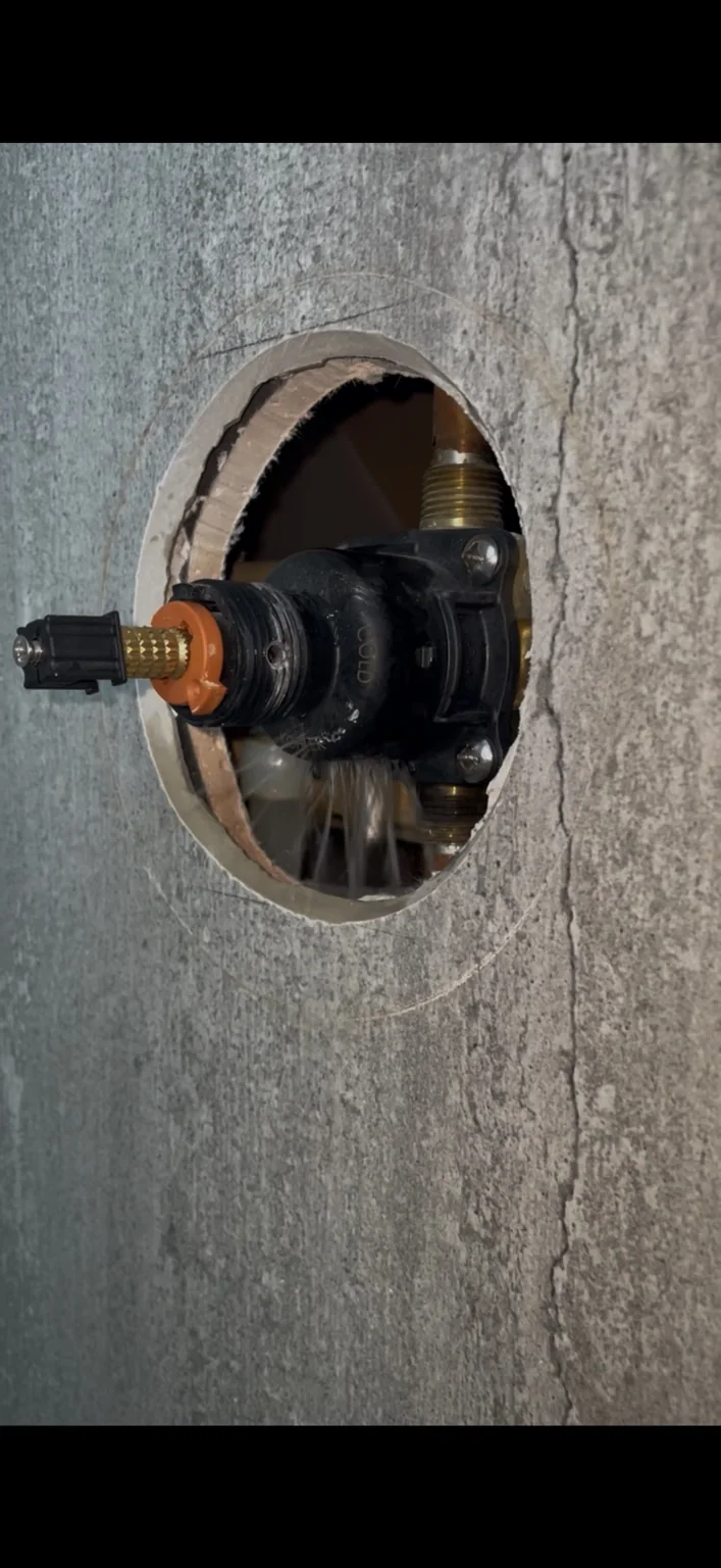 Emergency active water leak exposed behind a finished wall