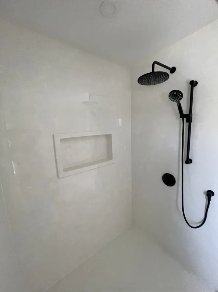 Finished white tiled shower with black fixtures